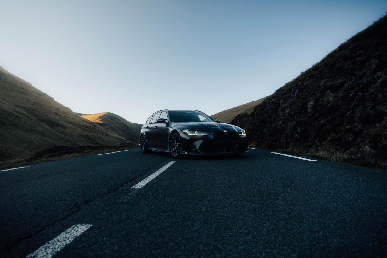 Photographie automobile : voiture de sport sur une route de montagne au crépuscule